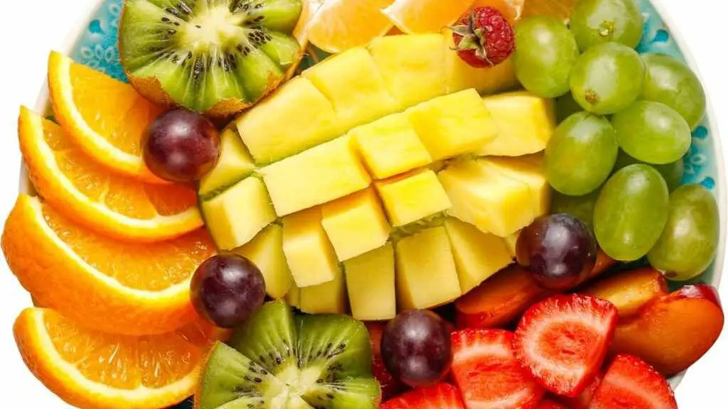  ripe mango slices surrounded by other fresh fruits.